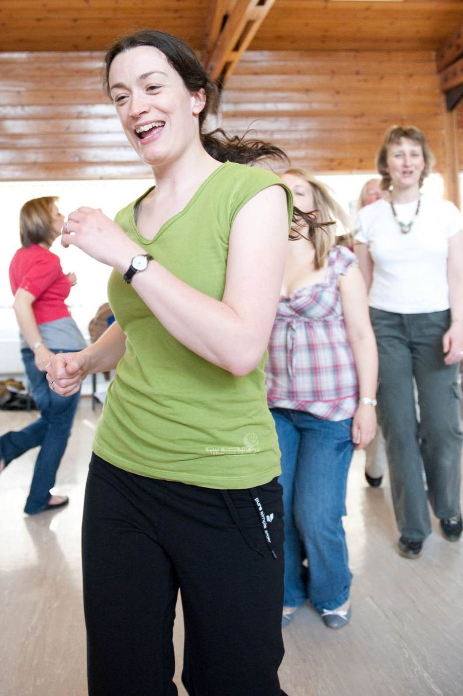 Kate laughing as she leads an action song with a group of grown-ups