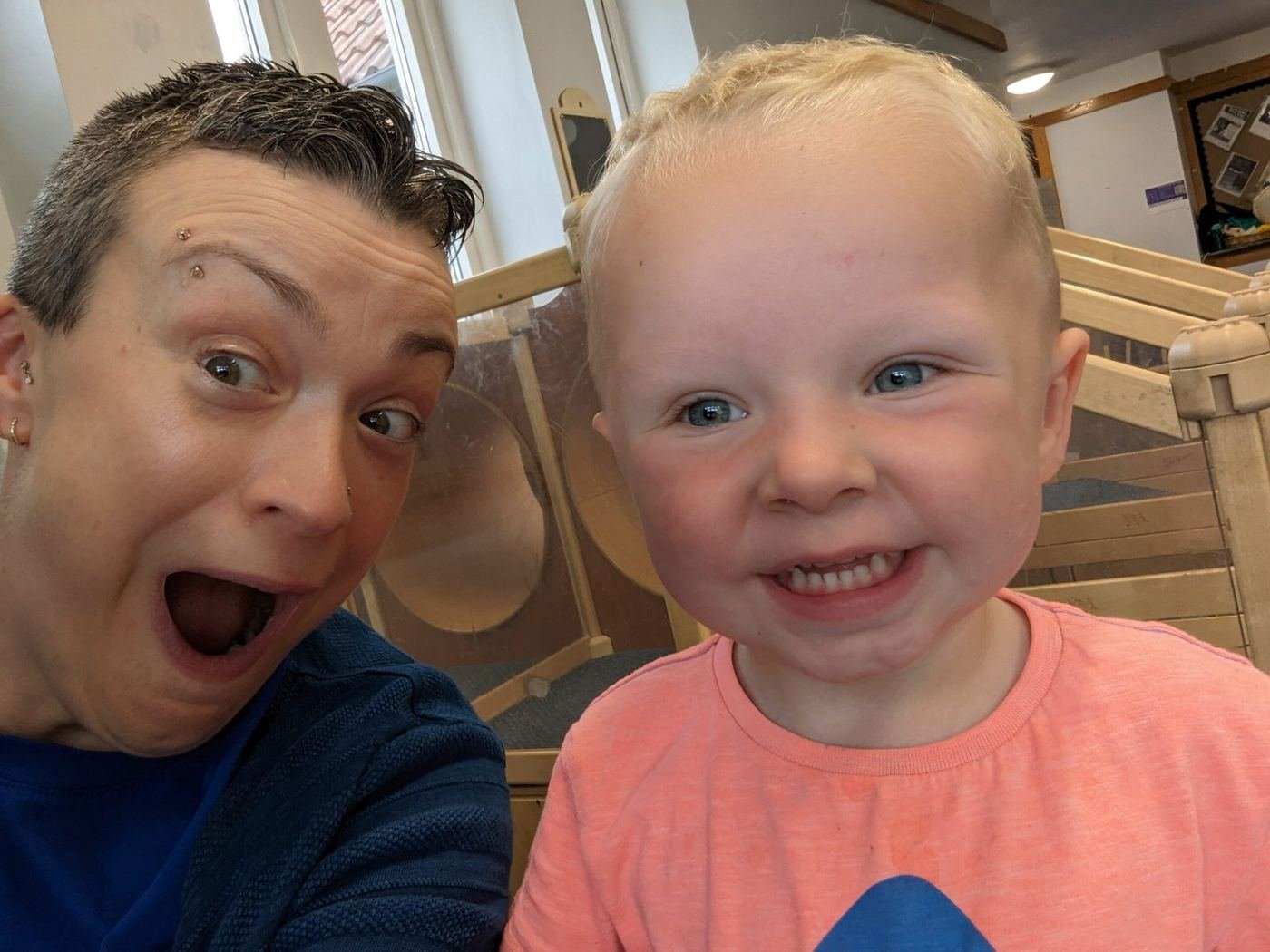 Kate pulling a surprised face in a selfie with a smiling little boy at nursery