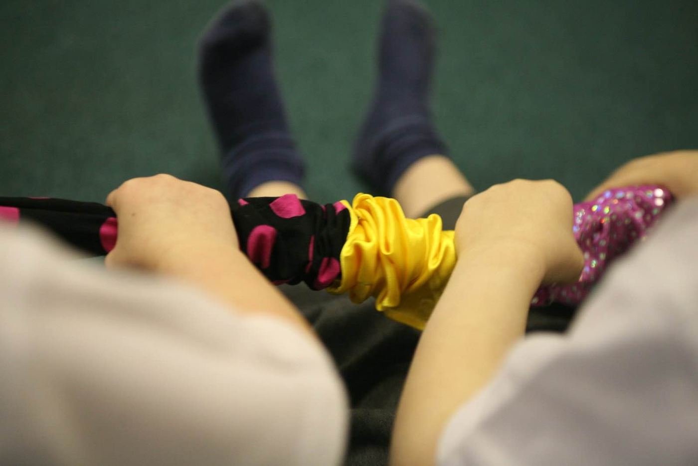 Hands holding a long, colourful fabric scrunchy
