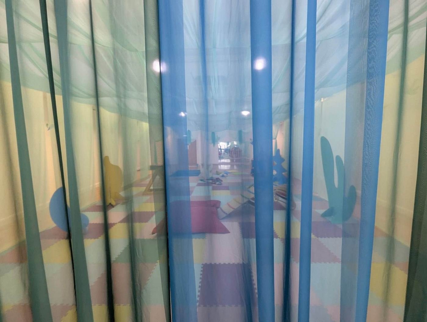 Soft blue voile curtains hanging in a play space, ready for a game of peekaboo